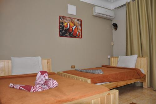 Cette chambre comprend 2 lits et une photo murale. dans l'établissement Dahab Plaza Hotel, à Dahab