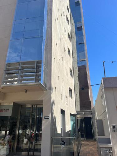 a tall building with a glass facade with a revolving door at Apart Civico Art. MARÍA ELINA 2 - PLENO CENTRO in San Juan