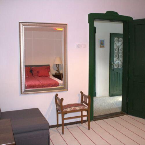 a bedroom with a mirror and a chair and a bed at Villa Délibáb in Badacsonytomaj