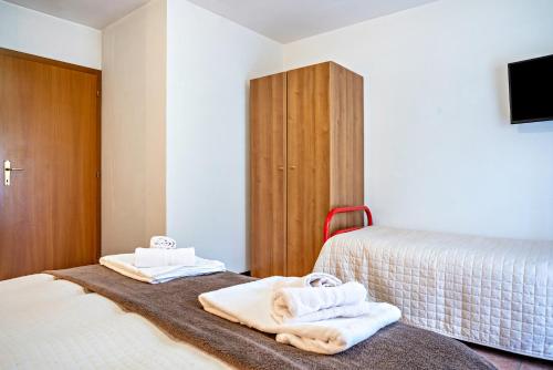 1 dormitorio con 2 camas y toallas. en Aparthotel Casinei Strembo, en Strembo