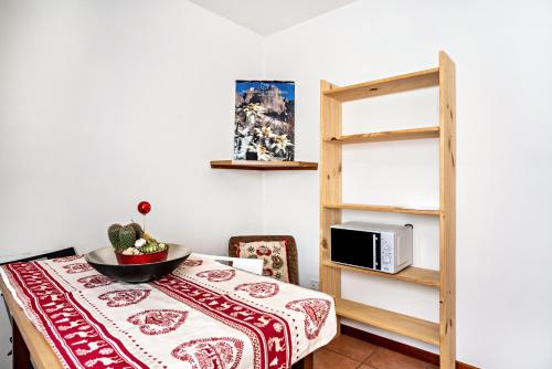 Habitación con mesa, microondas y estante. en Aparthotel Casinei Strembo, en Strembo