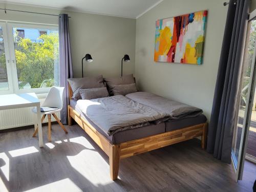 1 dormitorio con cama, escritorio y ventana en Ferienwohnung Bad Doberan - mit Garten und Terrasse - 2023 neu renoviert, en Bad Doberan