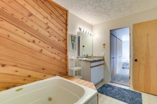a bathroom with a tub and a wooden wall at Trout Creek Resort Condo - 1 Mi to Nubs Nob! in Harbor Springs