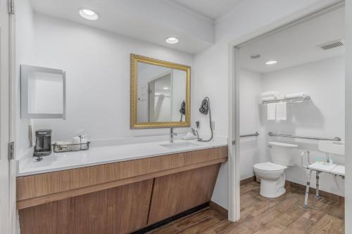 a bathroom with a sink and a toilet and a mirror at Crossroads Inn & Suites in Gatlinburg