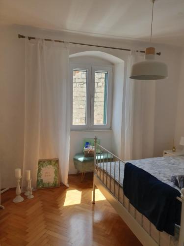 een slaapkamer met een bed en een raam bij Our Best Chapter in Split