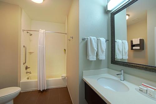 a bathroom with a sink and a shower and a toilet at Staybridge Suites Houston-NASA Clear Lake by IHG in Webster