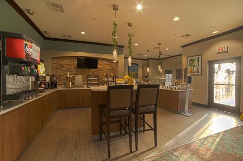 a restaurant with a bar with two chairs at a counter at Staybridge Suites Houston-NASA Clear Lake by IHG in Webster