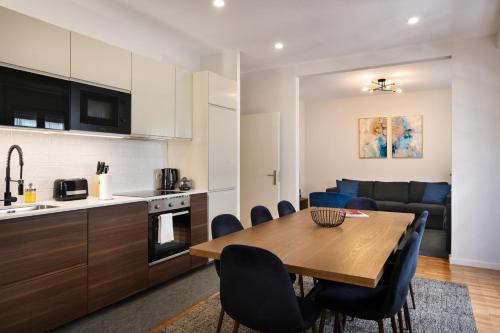 cocina y sala de estar con mesa de madera y sillas en Invicta Premium - Downtown apartment en Oporto