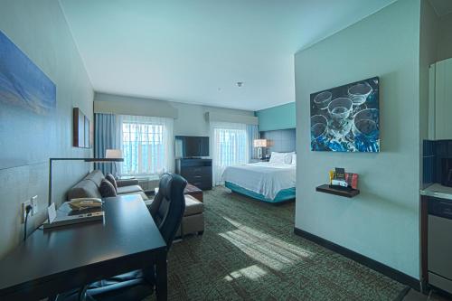 a hotel room with a bed and a desk at Staybridge Suites Houston-NASA Clear Lake by IHG in Webster