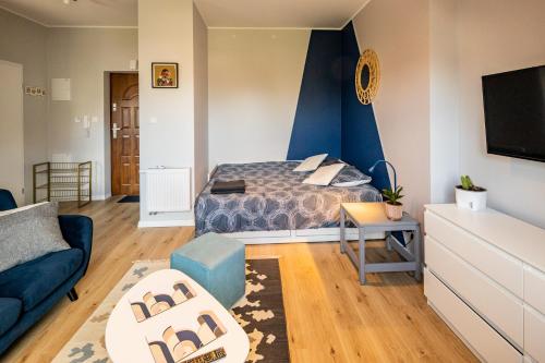 1 dormitorio con cama y pared de acento azul en Apartament Zakatek z miejscem parkingowym, en Bielsko-Biala