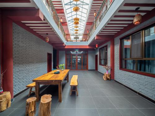 a dining room with a wooden table and benches at Dunhuang Hu Yang Inn in Dunhuang