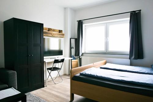 Schlafzimmer mit einem Bett, einem Fenster und einem Schreibtisch in der Unterkunft Heide Ferienwohnung in Schneverdingen