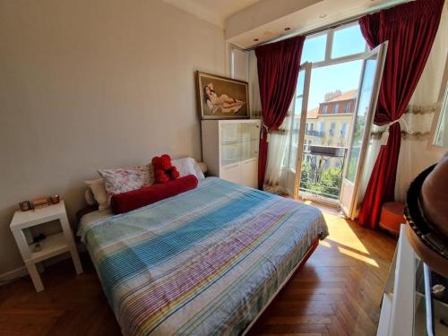 une chambre avec un lit avec un ours en peluche dessus dans l'établissement Nice : Beau trois pièces lumineuse avec vue dégagée., à Nice