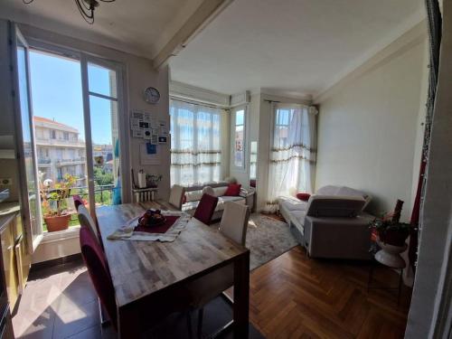 un salon avec une table et un canapé dans l'établissement Nice : Beau trois pièces lumineuse avec vue dégagée., à Nice