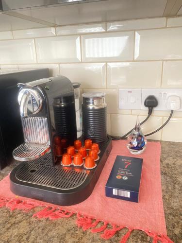 uma máquina de café sentada numa mesa com queques em Entire 4 bedroom House - EV POINT & FREE PARKING em Liverpool