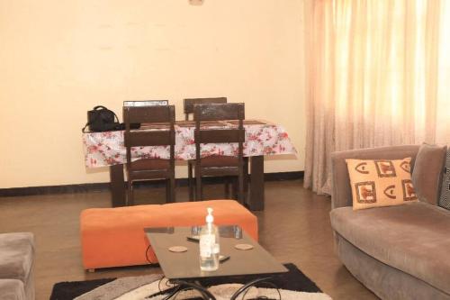 a living room with a table and a table and chairs at Maison de 3 chambres dans un lieu apaisé au centre de Kigali in Kigali