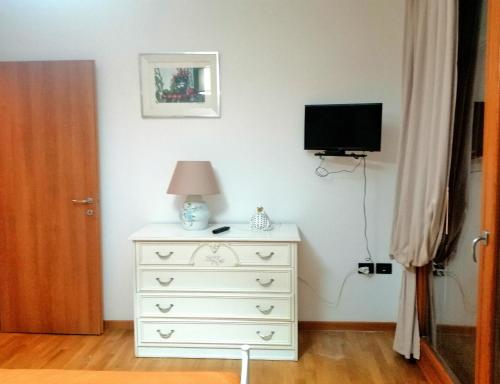 1 dormitorio con vestidor blanco y TV en la pared en Bilocale NICOL 4 posti Padova ovest, en Padua