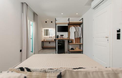 a white bedroom with a bed and a kitchen at Iades Studios & Apartments in Agia Anna Naxos