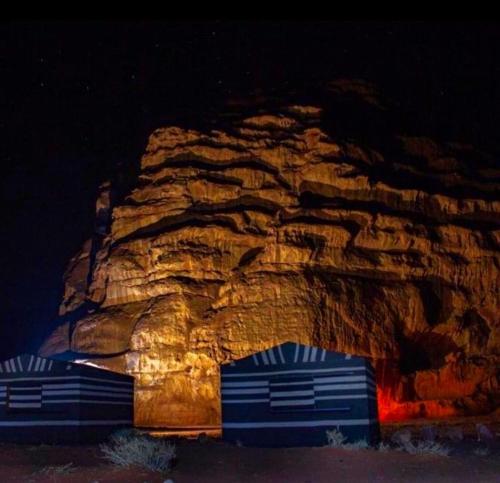 dois reboques azuis em frente a uma formação rochosa em Wadi Rum Meteorite camp em Wadi Rum