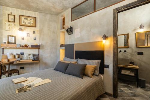 a bedroom with a bed in a room with a table at Via Roma Charming Rooms in Baunei