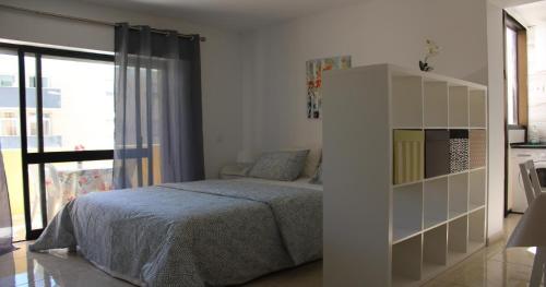 a bedroom with a bed and a book shelf at Casa Mirassol in Portimão