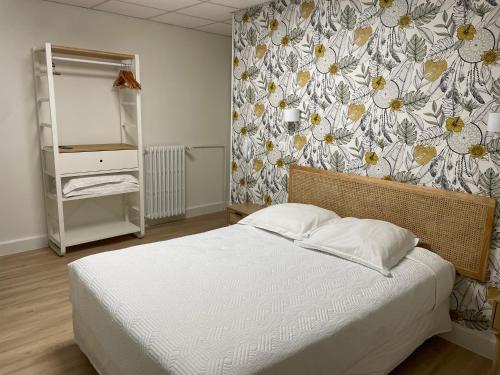 a bedroom with a bed and a floral wall at Hôtel La Vigneraie in Levens