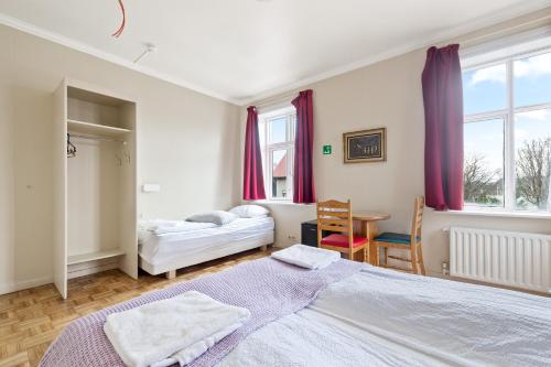 1 dormitorio con 2 camas y mesa. en Baldursbrá Guesthouse Laufásvegur en Reikiavik
