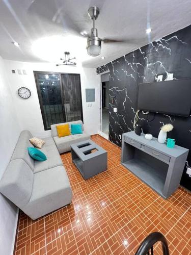 a living room with a couch and a tv at Casa Santa Cruz in Chetumal