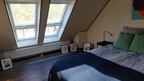 una camera da letto con due finestre e un letto con quadri incorniciati di Schöne Wohnung im Jugendstilhaus im Weltkulturerbe a Bacharach