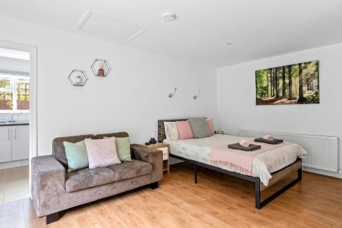 a living room with a bed and a couch at Number 2, Lytton Tree Lodge, Reydon, Southwold in Reydon
