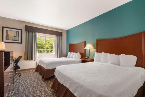 a hotel room with two beds and a window at SureStay Plus Hotel by Best Western Topeka in Topeka