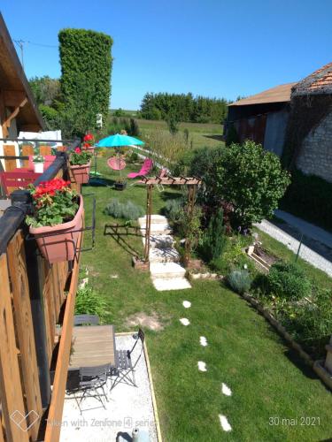 a backyard with a garden with plants and flowers at Gite Au Grenier Cosy in Lor