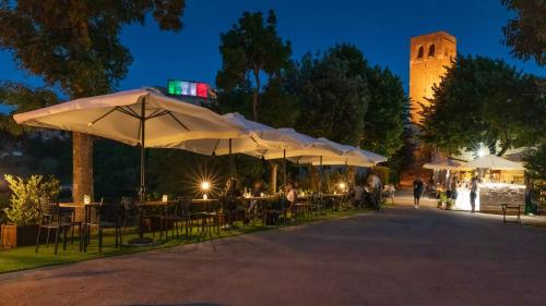 un grupo de mesas con sombrillas en un parque por la noche en Affittacamere Arcobaleno en San Leo