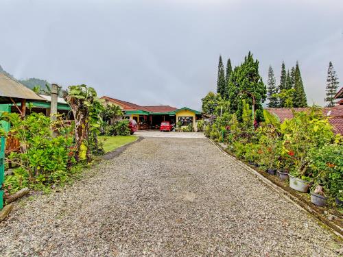 a gravel road in a garden with houses and trees at OYO 92534 Fajar Indah Guest House in Karanganyar