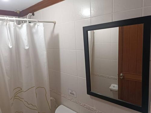 a bathroom with a shower curtain and a mirror at Isabelle Garden Villas 516 in Manila