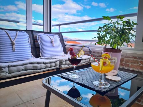 - une table en verre avec deux cocktails sur le balcon dans l'établissement Salona Terrace Apartment, à Solin