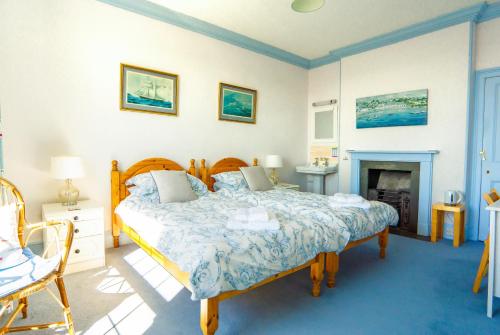 a bedroom with a bed and a fireplace at Ivy House Cornwall B&B in St Austell