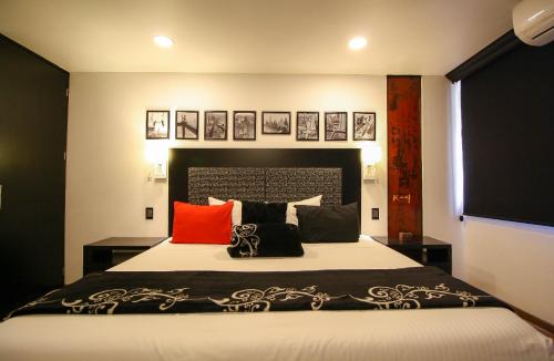 a bedroom with a bed with black and red pillows at Hotel Black Boutique in Mexico City