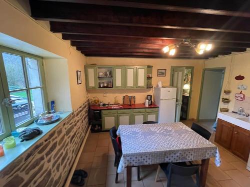 a kitchen with a table and a white refrigerator at Le Vaussourdet in Domfront