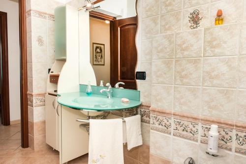 uma casa de banho com um lavatório e um espelho em A27 - Poggio, quadrilocale con vista sul mare di Portonovo em Ancona
