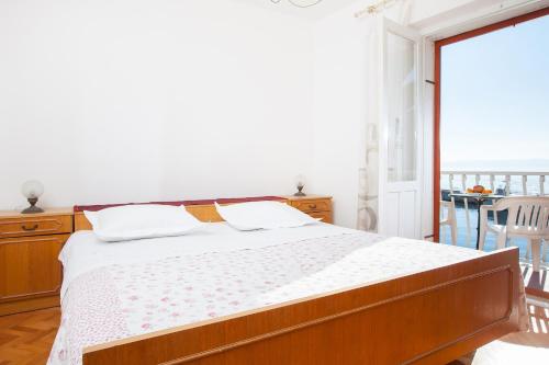 una camera da letto con un letto e un balcone di Apartments Teo a Podgora