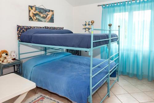 2 beliches num quarto com cortinas azuis em A27 - Poggio, quadrilocale con vista sul mare di Portonovo em Ancona