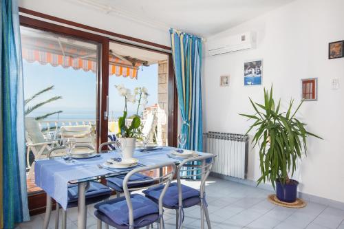 una sala da pranzo con tavolo e sedie e un balcone di Apartments Teo a Podgora