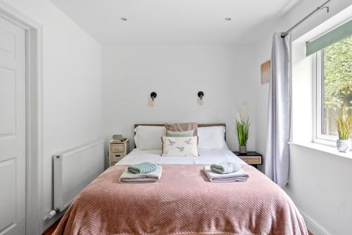 1 dormitorio con 1 cama con 2 toallas en Number 3, Lytton Tree Lodge, Reydon, Southwold en Reydon