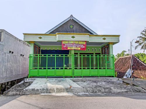 a green gate in front of a building at SPOT ON 92535 Guest House Pak Darso in Sragen