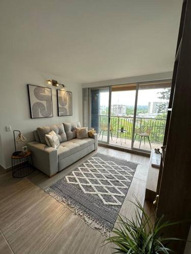 ein Wohnzimmer mit einem Sofa und einem großen Fenster in der Unterkunft New, cozy & stylish apartment in Armenia