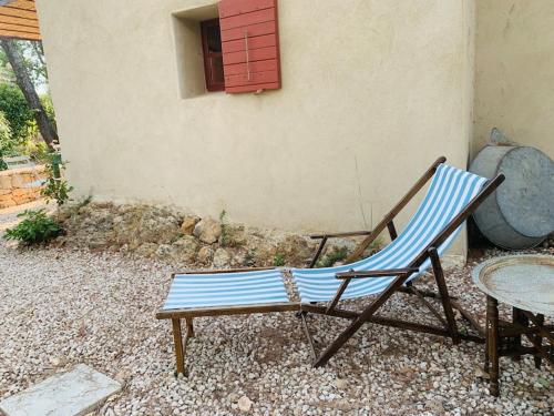 a chair and a table and a chair and a window at Un cabanon en Provence in Auriol