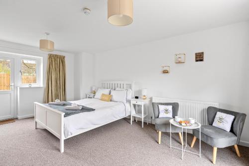 a bedroom with a bed and two chairs and a table at Number 5 - Lytton Tree Lodge, Reydon, Southwold in Reydon