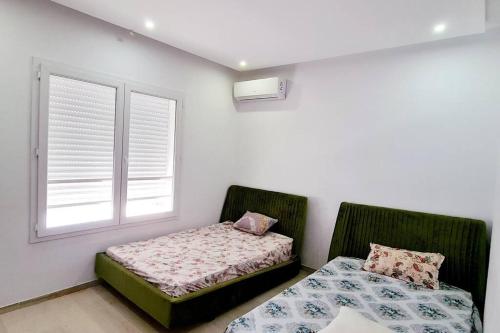 a bedroom with two beds and a window at Villa ilian in Monastir