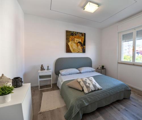 um quarto com uma cama num quarto branco em La Casetta a Santa em Santa Marinella